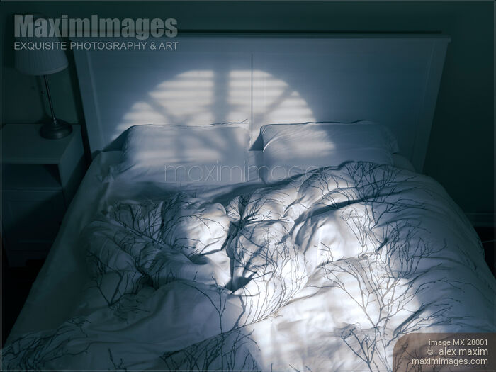 Stock photo of Unmade bed with light coming from a window Buy commercial use license at MaximImages