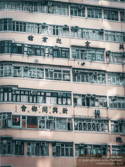 Stock photo of Wall of an urban residential high-rise building with balconies in Hong Kong China Buy commercial use license at MaximImages