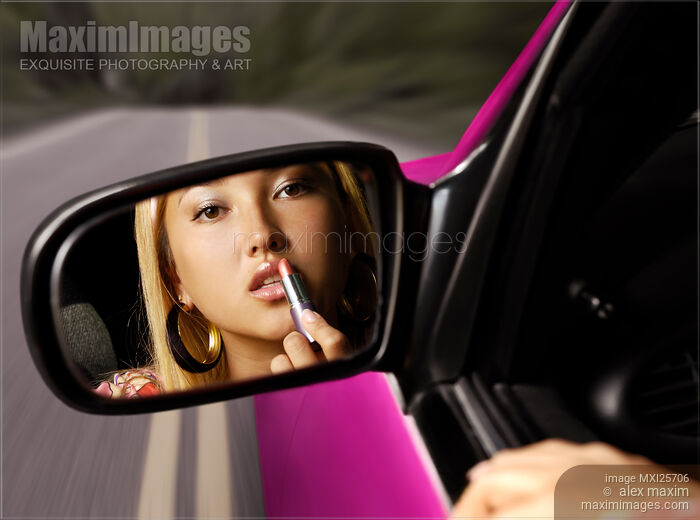 Stock photo of Woman Applying Lipstick in a Car Buy commercial use license at MaximImages