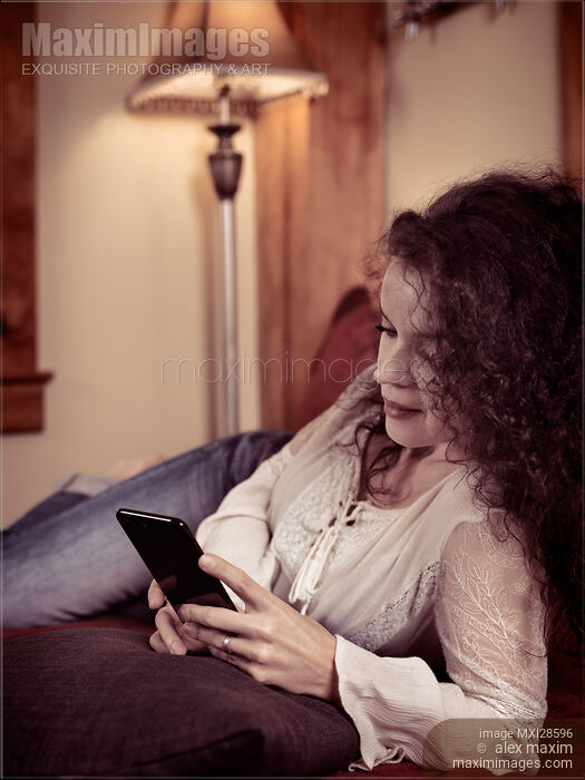 Stock photo of Woman at home using iPhone 7 Plus smartphone Buy commercial use license at MaximImages