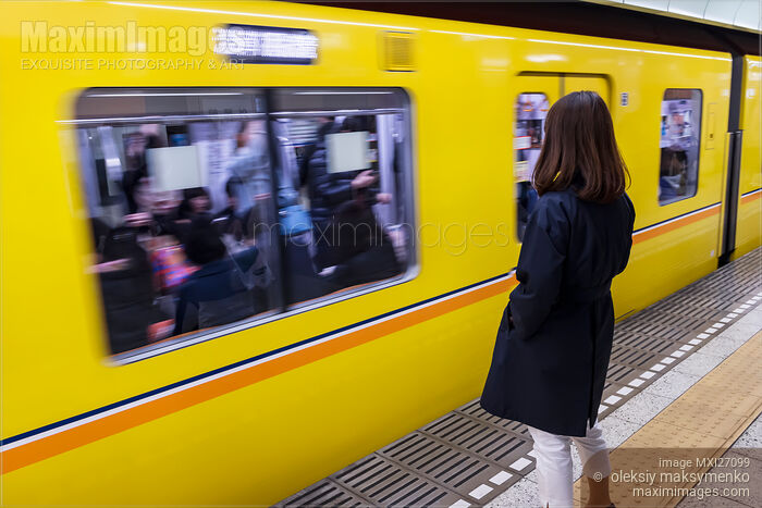 Stock photo of Woman at subway platform waiting for train Buy commercial use license at MaximImages