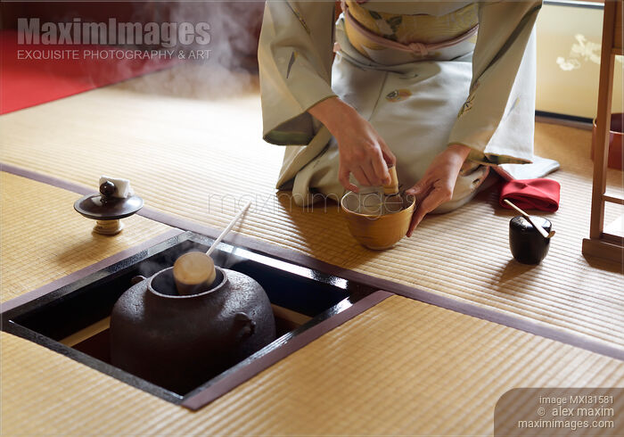 Stock photo of Woman blending matcha tea with a whisk by a steaming iron kettle in a Japanese tea house Buy commercial use license at MaximImages