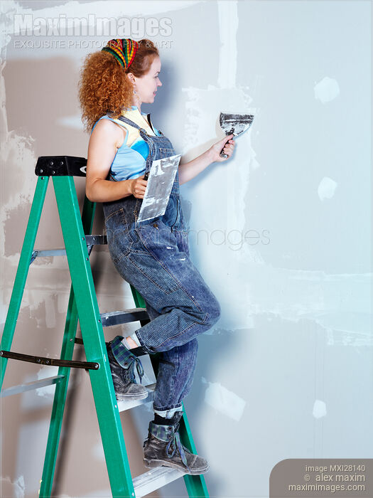Woman construction worker on a ladder patching up drywall Stock photo of Woman construction worker on a ladder patching up drywall Buy commercial use license at MaximImages