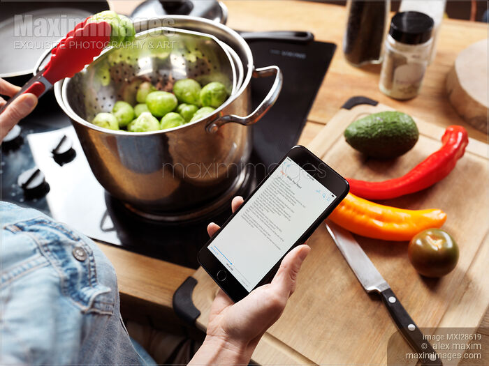 Woman cooking reading recipe from iPhone 7 Stock photo of Woman cooking reading recipe from iPhone 7 Buy commercial use license at MaximImages