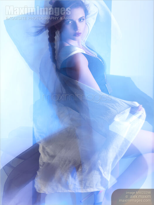 Woman dancing surrounded with blue shiny light Stock photo of Woman dancing surrounded with blue shiny light Buy commercial use license at MaximImages