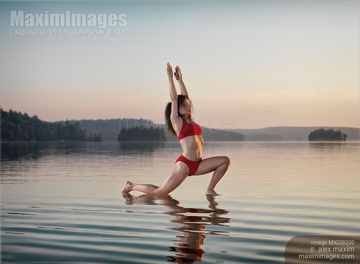 Stock photo of Woman doing Hatha yoga Anjaneyasana Low Lunge pose on the water Buy commercial use license at MaximImages