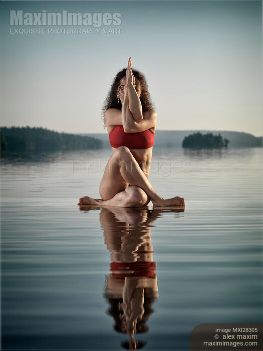 Woman doing sitting variation of yoga Eagle pose on the water Stock photo of Woman doing sitting variation of yoga Eagle pose on the water Buy commercial use license at MaximImages