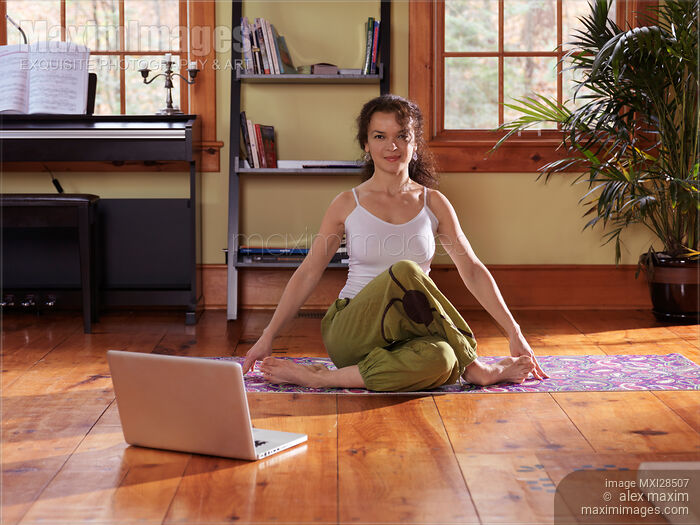 Stock photo of Woman doing yoga at home in living room Buy commercial use license at MaximImages