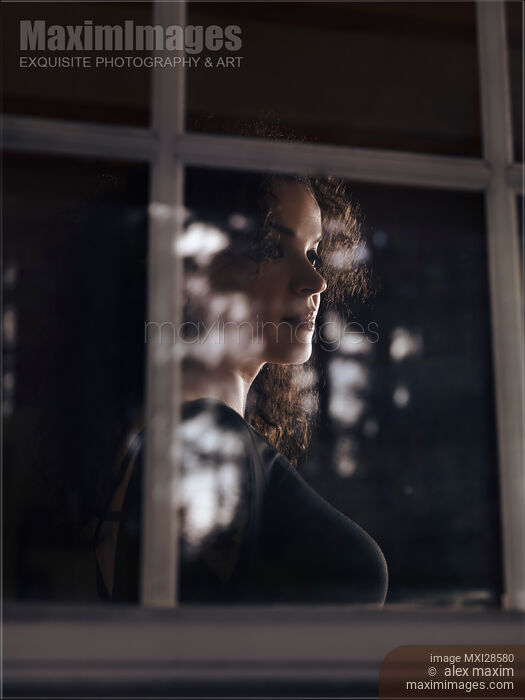 Stock photo of Woman face behind reflections on the window pane Buy commercial use license at MaximImages