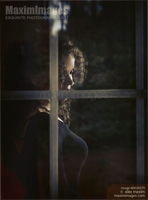 Stock photo of Woman face behind window glass Buy commercial use license at MaximImages