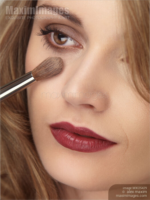 Stock photo of Woman face with makeup brush applying foundation Buy commercial use license at MaximImages
