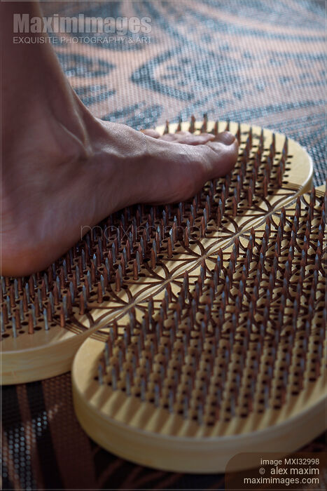 Stock photo of Woman foot standing on Sadhu Board Yogic board of nails Closeup Buy commercial use license at MaximImages