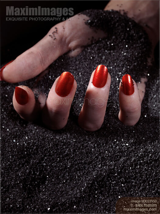 Woman Hand With Red Nails on Black Sand Stock photo of Woman Hand With Red Nails on Black Sand Buy commercial use license at MaximImages