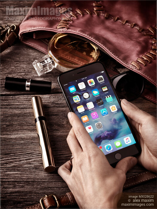 Stock photo of Woman hands with iPhone 7 with her purse and accessories Buy commercial use license at MaximImages