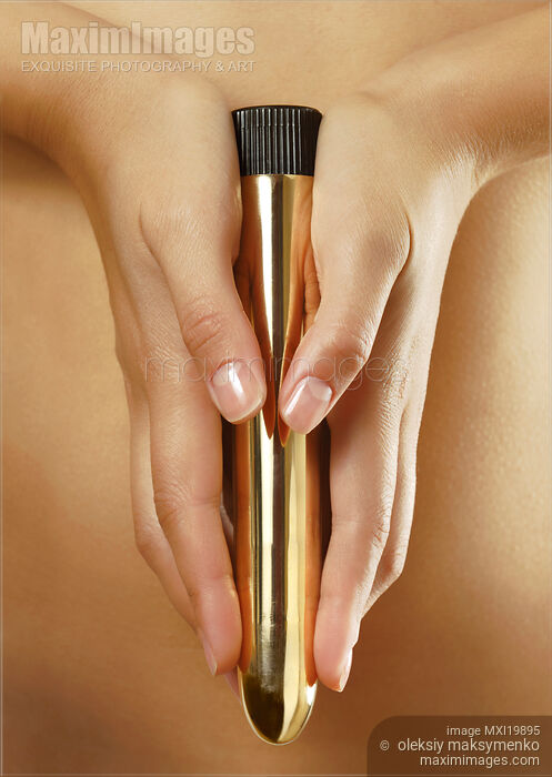 Woman Holding a Gold Vibrator Stock photo of Woman Holding a Gold Vibrator Buy commercial use license at MaximImages