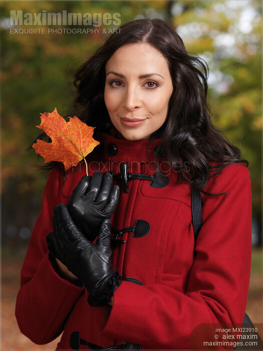 Stock photo of Woman Holding a Red Maple Leaf Buy commercial use license at MaximImages