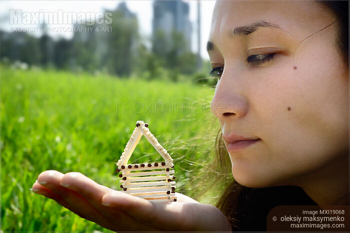 Stock photo of Woman holding house from matches in hand Buy commercial use license at MaximImages