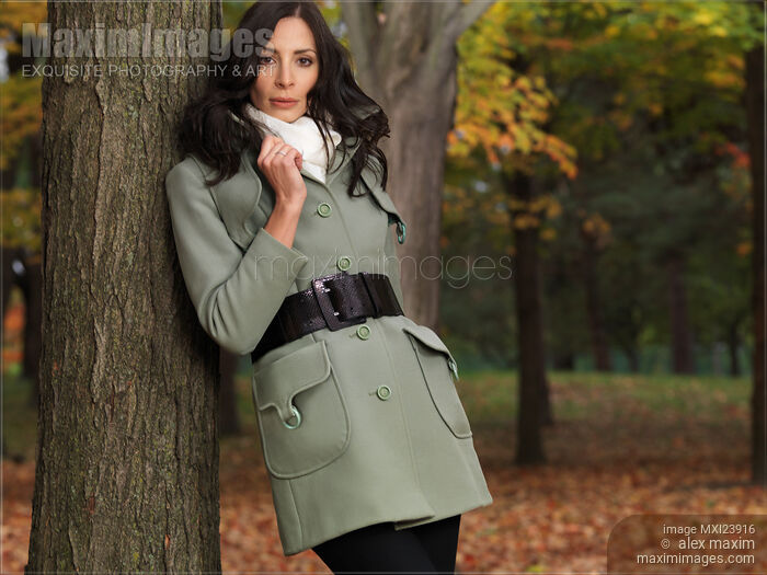 Woman in a Fall Season Coat Leaning Against a Tree Stock photo of Woman in a Fall Season Coat Leaning Against a Tree Buy commercial use license at MaximImages
