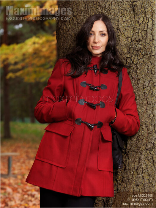Woman in a Red Coat Leaning Against a Tree Stock photo of Woman in a Red Coat Leaning Against a Tree Buy commercial use license at MaximImages