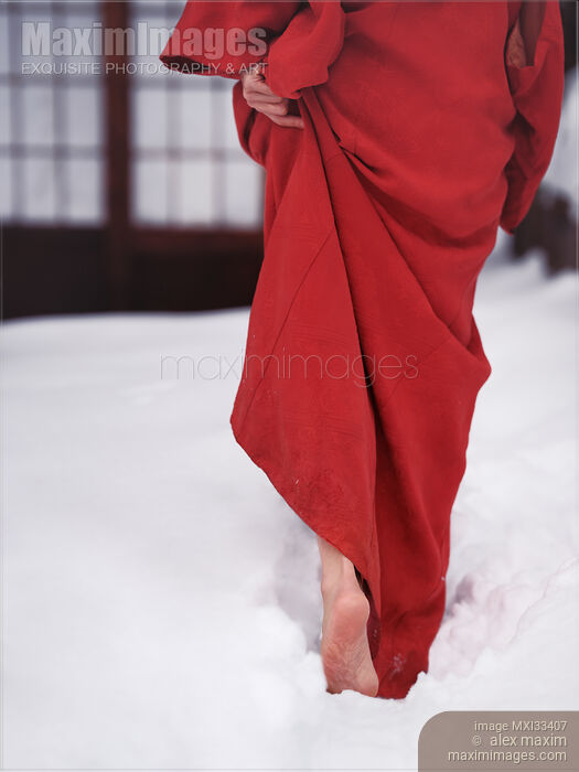 Stock photo of Woman in red kimono walking barefoot in deep white snow towards traditional Japanese house Buy commercial use license at MaximImages