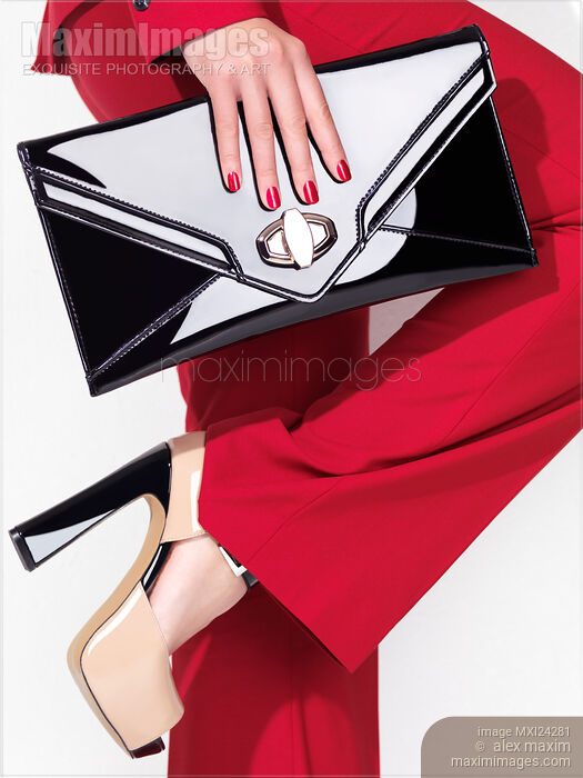 Woman in red suit and platform shoes with a clutch Stock photo of Woman in red suit and platform shoes with a clutch Buy commercial use license at MaximImages
