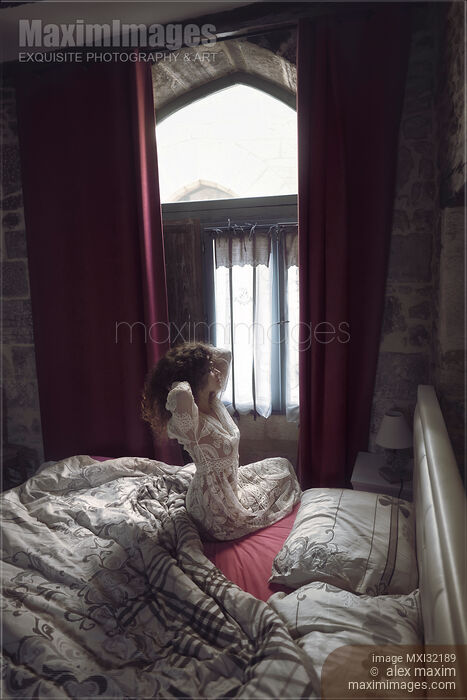 Woman just awaken in the morning stretching in bed by the window Stock photo of Woman just awaken in the morning stretching in bed by the window Buy commercial use license at MaximImages