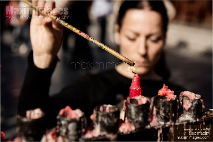 Stock photo of Woman lighting incense at Buddhist Temple Buy commercial use license at MaximImages