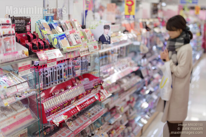 Stock photo of Woman looking at makeup display of Japanese beauty product store Buy commercial use license at MaximImages