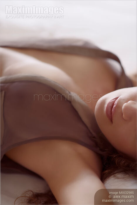 Woman lying in bed with her dress open on her chest Sensual closeup of lips in soft white light Making love artistic concept Stock photo of Woman lying in bed with her dress open on her chest Sensual closeup of lips in soft white light Making love artistic concept Buy commercial use license at MaximImages
