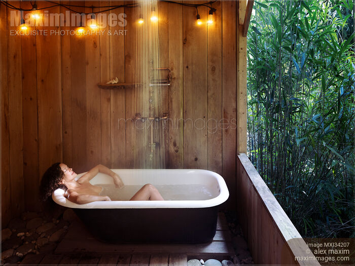 Woman lying naked relaxed in open-air bath tub in a rustic countryside cabin Stock photo of Woman lying naked relaxed in open-air bath tub in a rustic countryside cabin Buy commercial use license at MaximImages