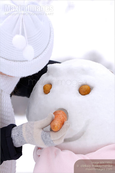 Stock photo of Woman Making a Snowman Buy commercial use license at MaximImages