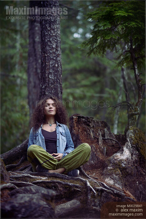 Woman meditating in forest sitting in meditation pose leaning against tree trunk in nature Stock photo of Woman meditating in forest sitting in meditation pose leaning against tree trunk in nature Buy commercial use license at MaximImages