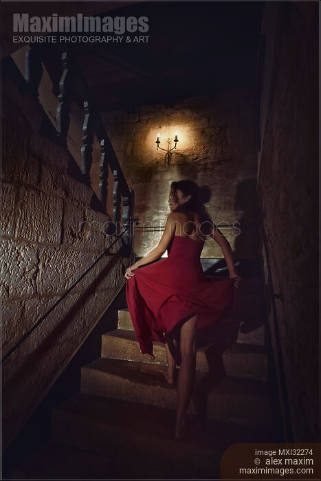 Stock photo of Woman on a staircase of an old house running barefoot upstairs in fear Buy commercial use license at MaximImages