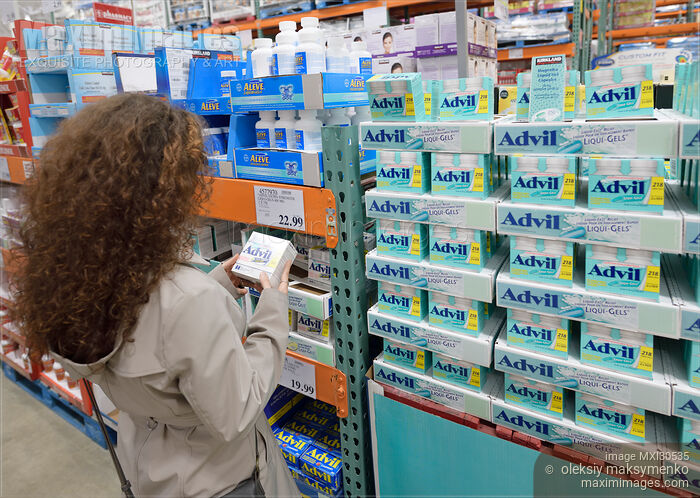 Stock photo of Woman picking Advil pain relief medications at Costco Wholesale warehouse store pharmacy Buy commercial use license at MaximImages