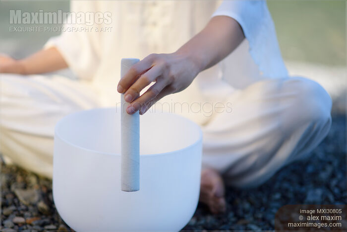 Woman playing a quartz crystal singing bowl for healing sound therapy Stock photo of Woman playing a quartz crystal singing bowl for healing sound therapy Buy commercial use license at MaximImages