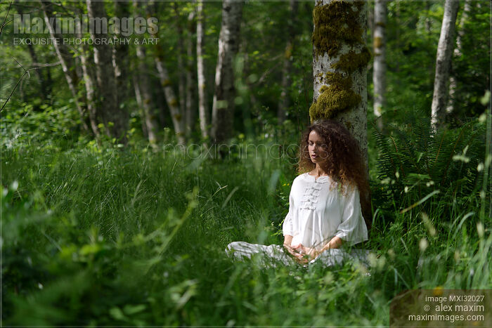 Woman practicing sitting meditation leaning against a tree trunk in a birch forest Stock photo of Woman practicing sitting meditation leaning against a tree trunk in a birch forest Buy commercial use license at MaximImages