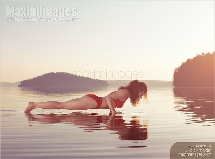 Woman practicing yoga on platform in the water Plank pose Stock photo of Woman practicing yoga on platform in the water Plank pose Buy commercial use license at MaximImages