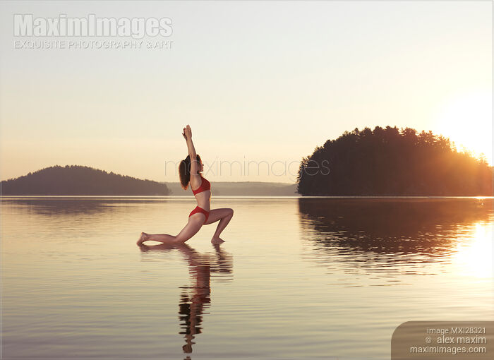 Woman practicing yoga on the water Anjaneyasana Low Lunge pose Stock photo of Woman practicing yoga on the water Anjaneyasana Low Lunge pose Buy commercial use license at MaximImages