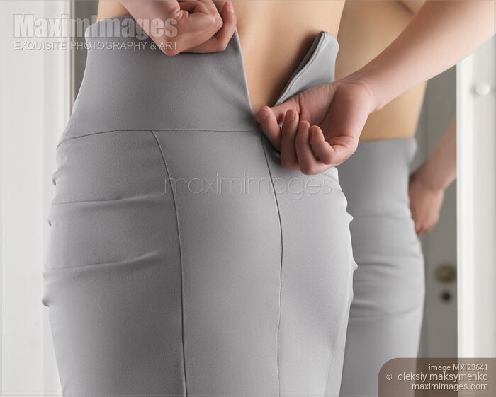 Stock photo of Woman Putting On a Skirt Buy commercial use license at MaximImages
