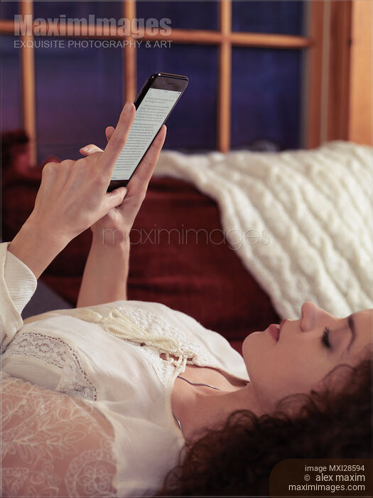 Stock photo of Woman reading book on iPhone 7 Buy commercial use license at MaximImages