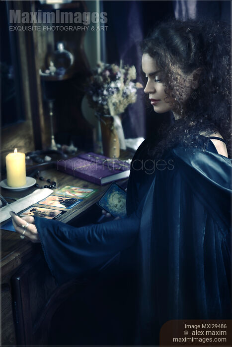 Stock photo of Woman reading Tarot cards at a table Buy commercial use license at MaximImages