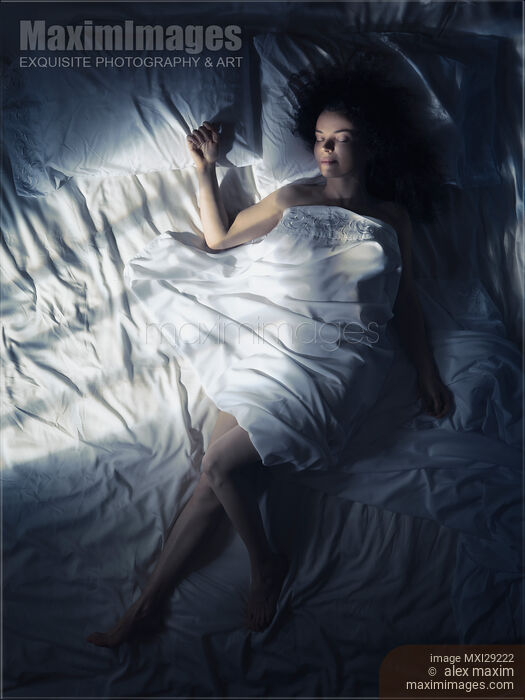 Stock photo of Woman sleeping in bed at night in dark bedroom Buy commercial use license at MaximImages