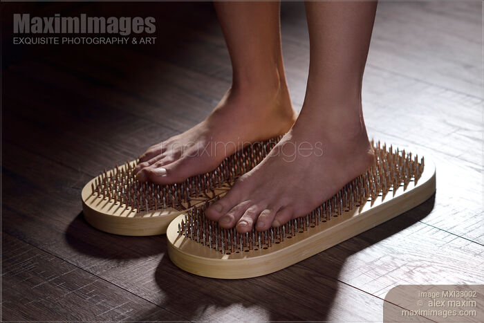 Woman standing on Sadhu Board Yogic board of nails with bare feet Stock photo of Woman standing on Sadhu Board Yogic board of nails with bare feet Buy commercial use license at MaximImages