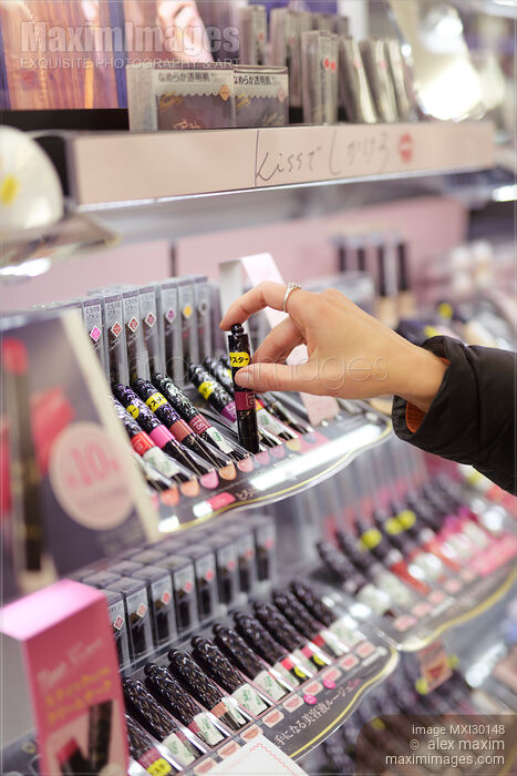 Stock photo of Woman taking lip gloss lipstick tester in a Japanese makeup store Buy commercial use license at MaximImages