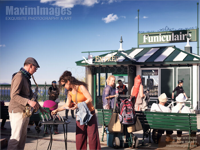 Stock photo of Woman tourist buying CD of street musician in Quebec city Buy commercial use license at MaximImages