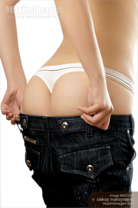 Woman trying to fit in her jeans Stock photo of Woman trying to fit in her jeans Buy commercial use license at MaximImages