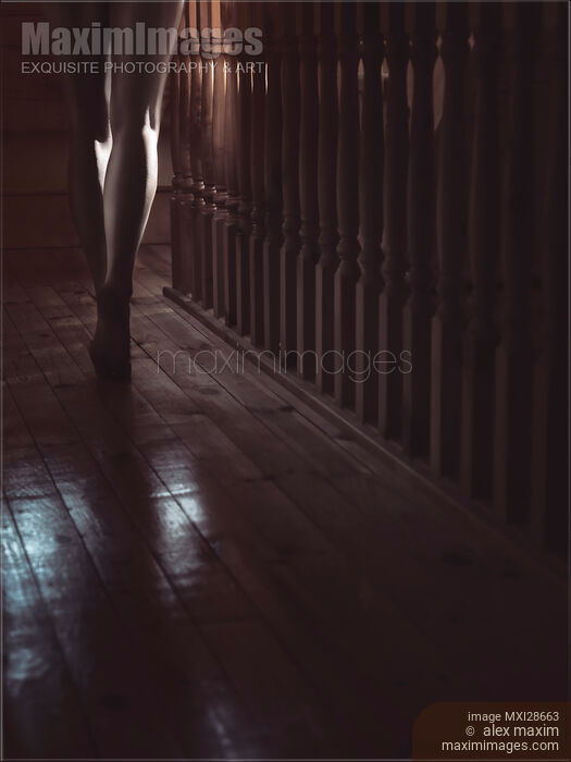 Stock photo of Woman walking barefoot in dark house Closeup of legs Buy commercial use license at MaximImages
