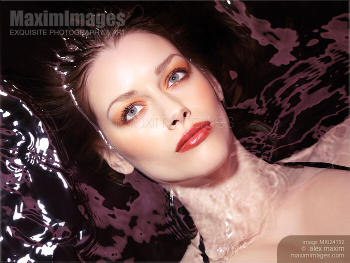 Stock photo of Woman wearing makeup and red lipstick lying in water Buy commercial use license at MaximImages