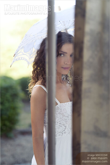 Woman with a French lace parasol standing outside the house behind a closed door Stock photo of Woman with a French lace parasol standing outside the house behind a closed door Buy commercial use license at MaximImages