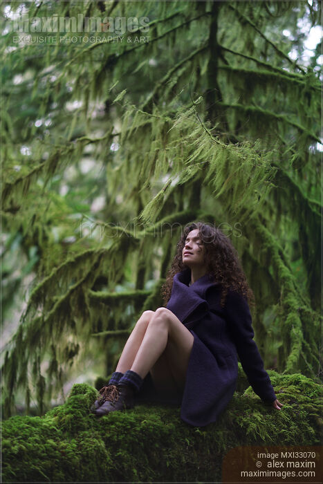 Woman with dreamy expression sitting on mossy tree trunk in purple coat with bare legs in moody green forest nature scenery Stock photo of Woman with dreamy expression sitting on mossy tree trunk in purple coat with bare legs in moody green forest nature scenery Buy commercial use license at MaximImages